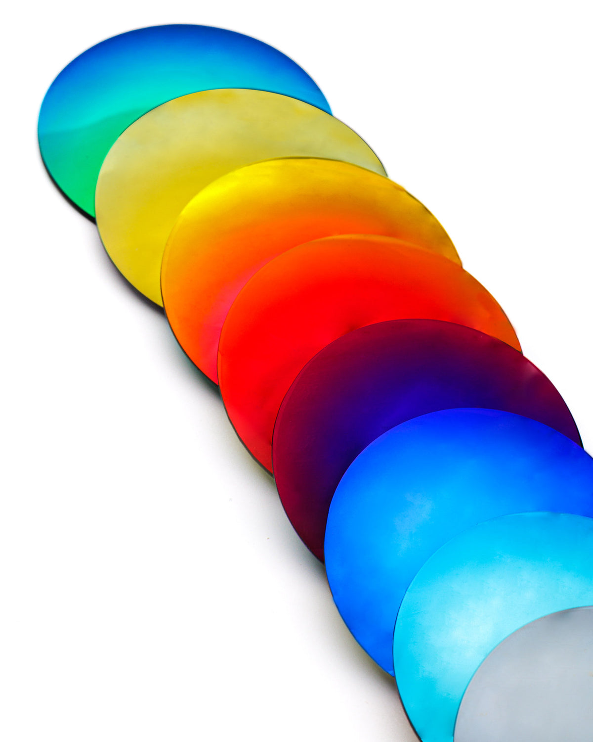 Nove lenti Rilens di colori diversi disposte a ventaglio su fondo bianco